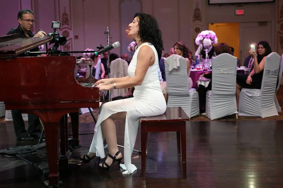 Anahit playing grand piano at a gala
